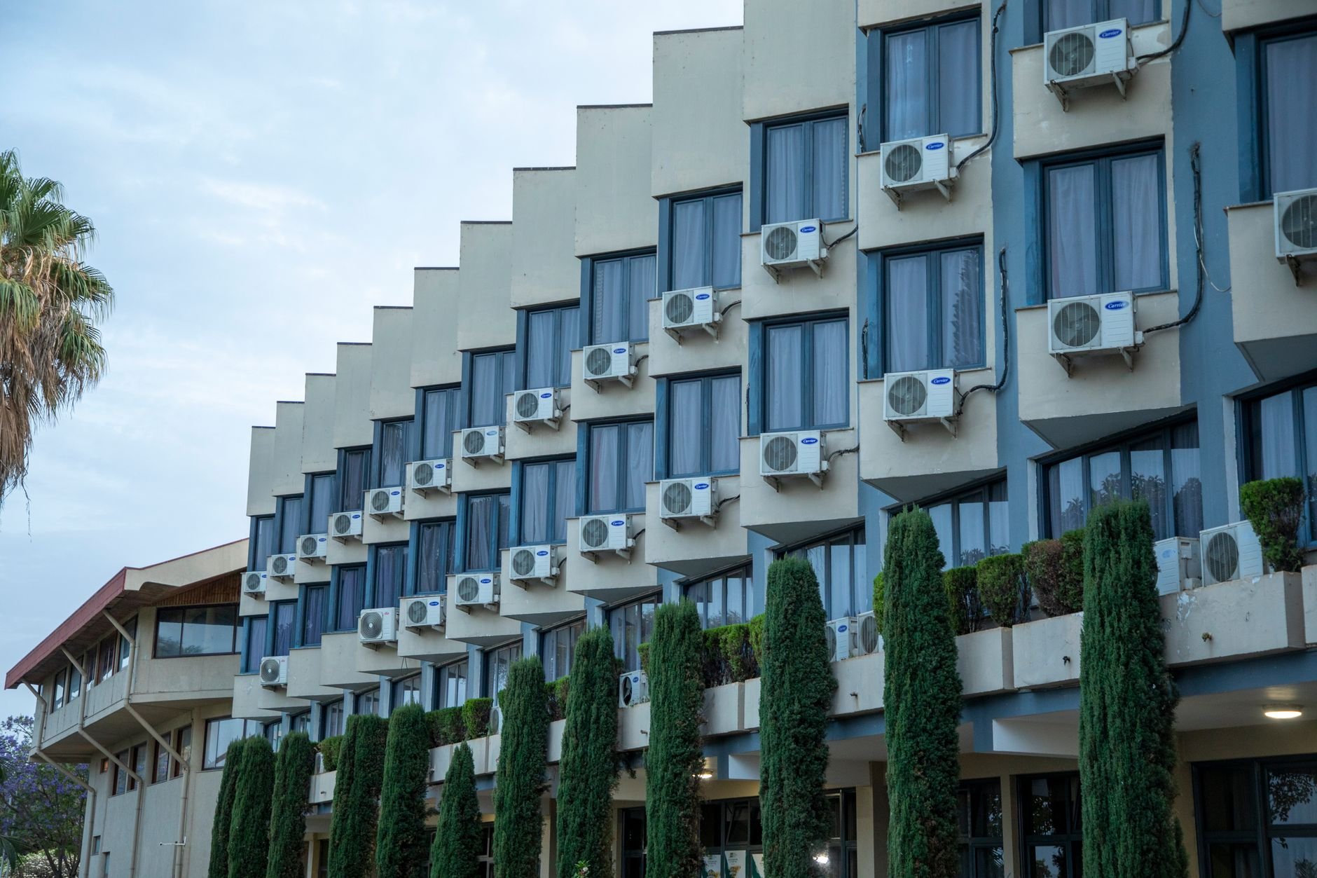 Exterior of a building featuring rows of air conditioning units against a clear sky
